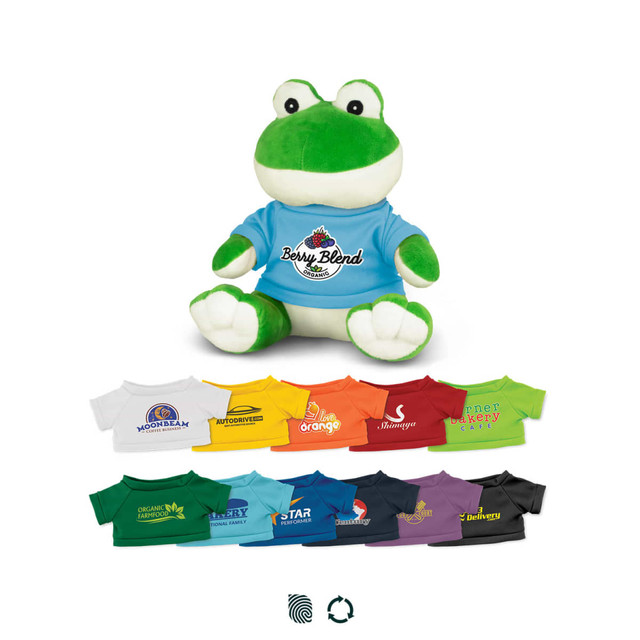 A green frog plush toy wearing a blue shirt, accompanied by a variety of colourful T-shirts in different shades.