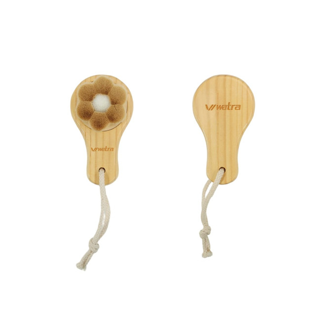A flower-shaped facial cleansing brush with a wooden handle, featuring a soft bristle head. It has a logo and a hanging cord.
