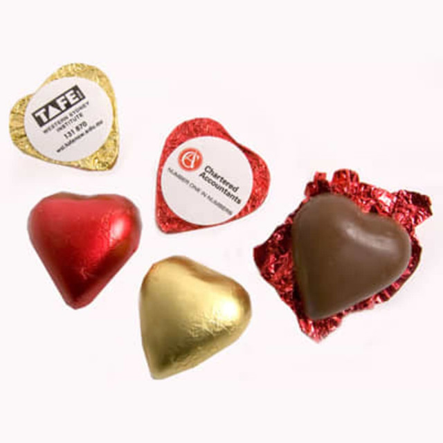 A selection of chocolate hearts in red, gold, and brown foil, some featuring branded stickers.