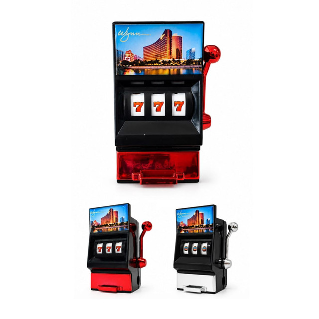A vibrant red and black fridge magnet resembling a slot machine, complete with a sharpener and a scenic backdrop.