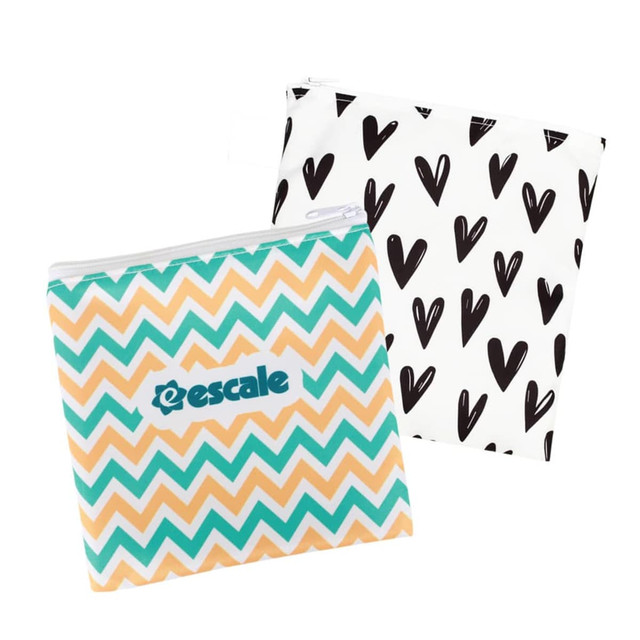 A set of two reusable food pouches featuring a turquoise and orange chevron pattern and a black heart design, both with zippers.