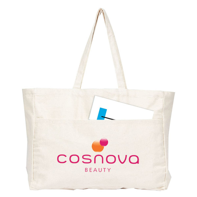 A large cream canvas tote bag with a front pocket and a logo. A sheet of paper is partially visible inside the bag. A large cream canvas tote bag with a front pocket and a logo. A sheet of paper is partially visible inside the bag.