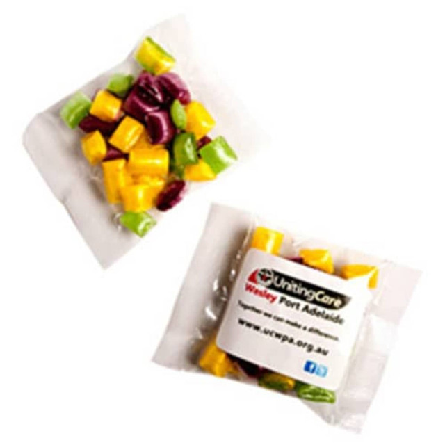 A branded bag containing assorted humbug sweets in yellow, green, and purple. A branded bag containing assorted humbug sweets in yellow, green, and purple.