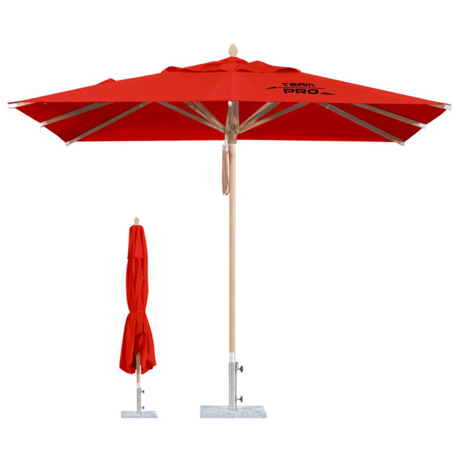 A red, wind-resistant square outdoor umbrella with a wooden pole and a base, alongside a folded version.