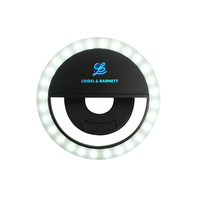 A round, black selfie ring light with white LEDs around the edge and a central opening for attaching to devices.