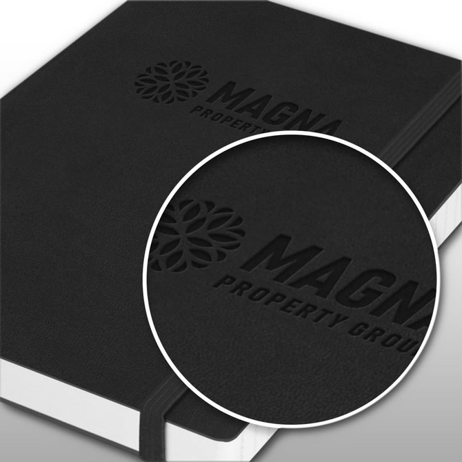 A black Hudson Notebook featuring a textured cover and a logo. The notebook has a white spine and elastic closure.