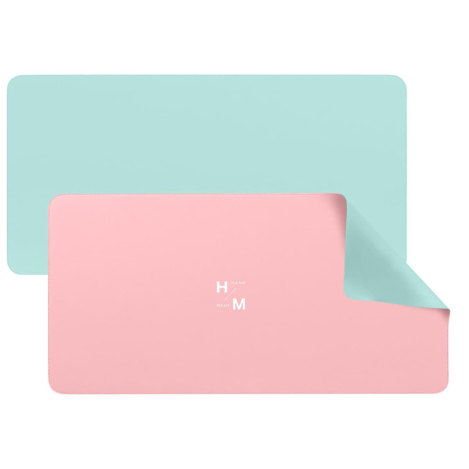 A PU leather desk mat featuring a dual-sided design with mint green and pastel pink colours, including a logo.
