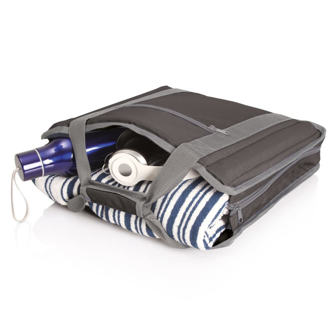 A black carry bag with grey accents, containing a drink bottle and a striped towel, with headphones visible.
