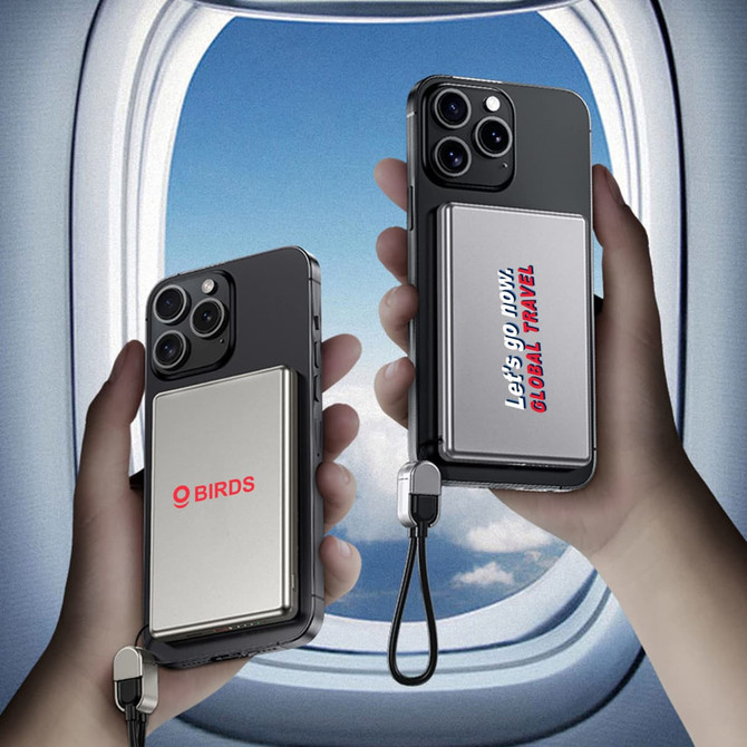 A silver 5000mAh aluminum magnetic power bank attached to a smartphone, displayed against a window view of the sky.