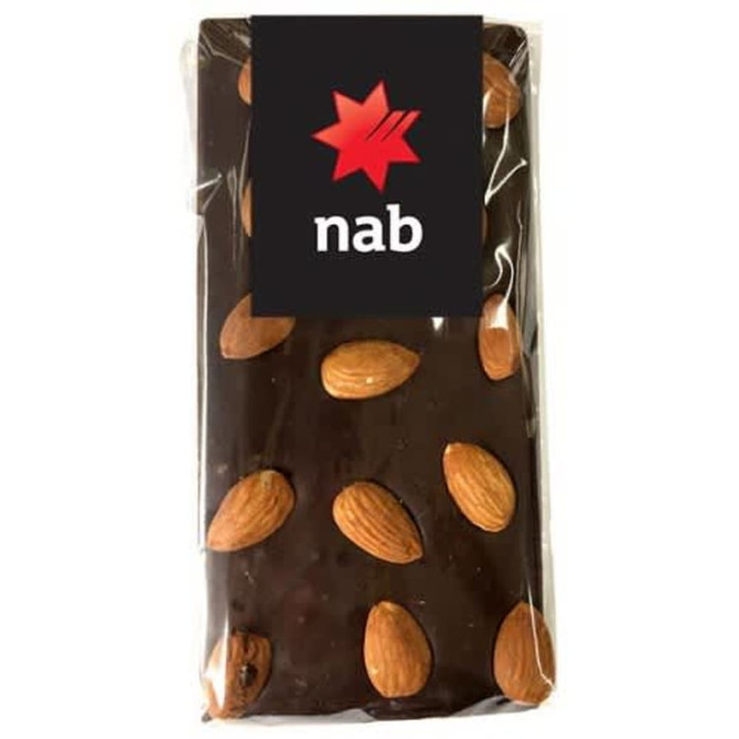A chocolate bar with a dark coating and whole almonds scattered on top, sealed in clear packaging with a logo.