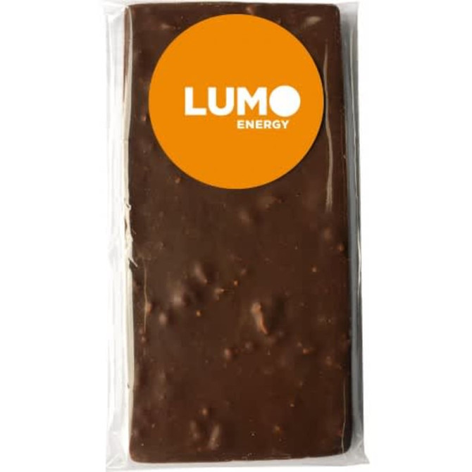 A rectangular chocolate bar in a clear wrapper, featuring a logo. The chocolate has a brown colour with a textured surface.