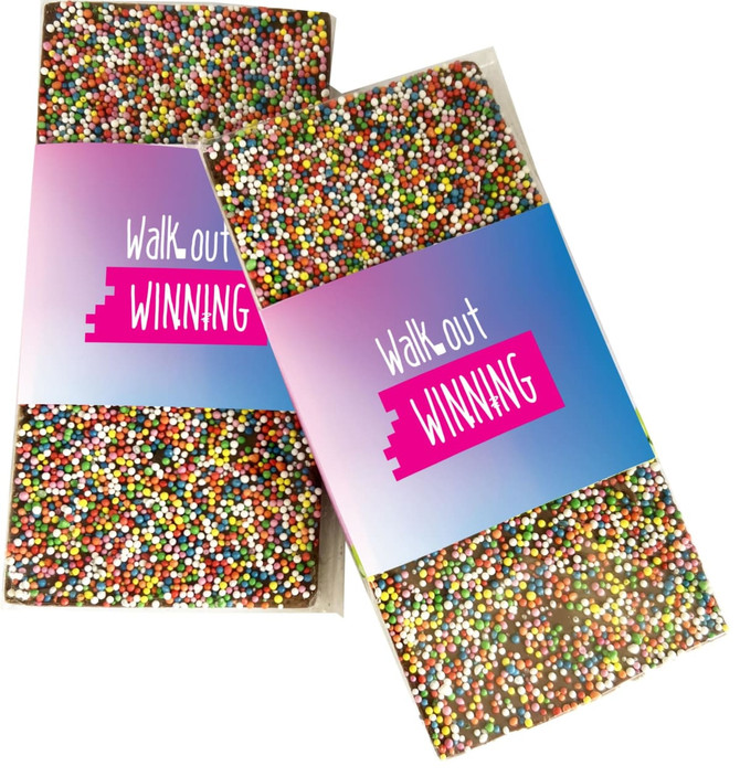 A pack of premium chocolate sprinkled with colourful 100s and 1000s, featuring a branded label.
