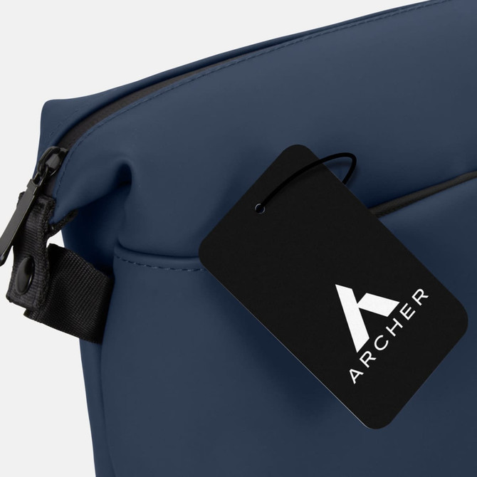 A navy blue soft-touch toiletry bag featuring a branding tag. The bag has a zip closure and a sleek design.