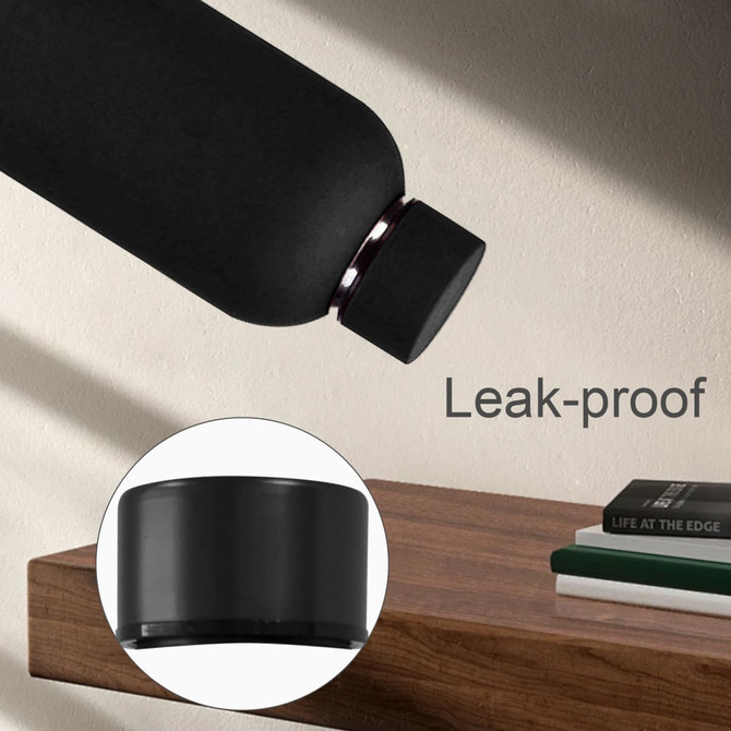 A drink bottle in matte black with a leak-proof cap, showcasing its sleek design against a wooden surface.