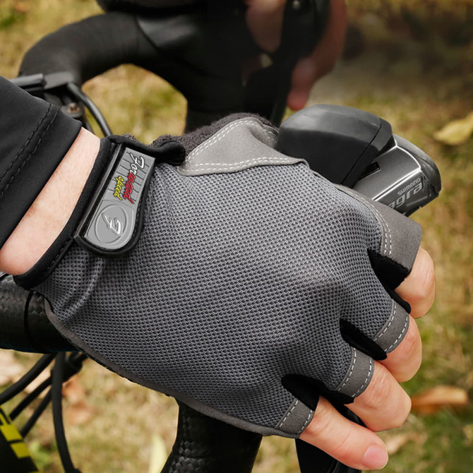 Anti-slip bike gloves in grey, featuring a textured surface and an adjustable strap, shown on a cyclist's hand.
