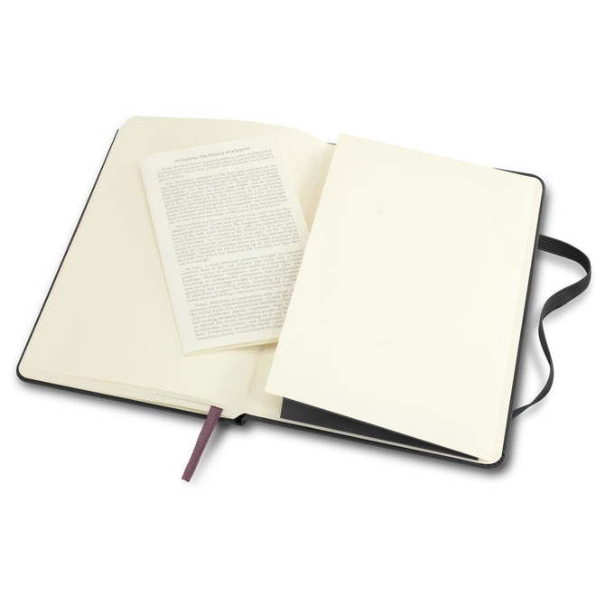 A large black Moleskine Classic Hard Cover Notebook, open to reveal cream pages and a blank insert.