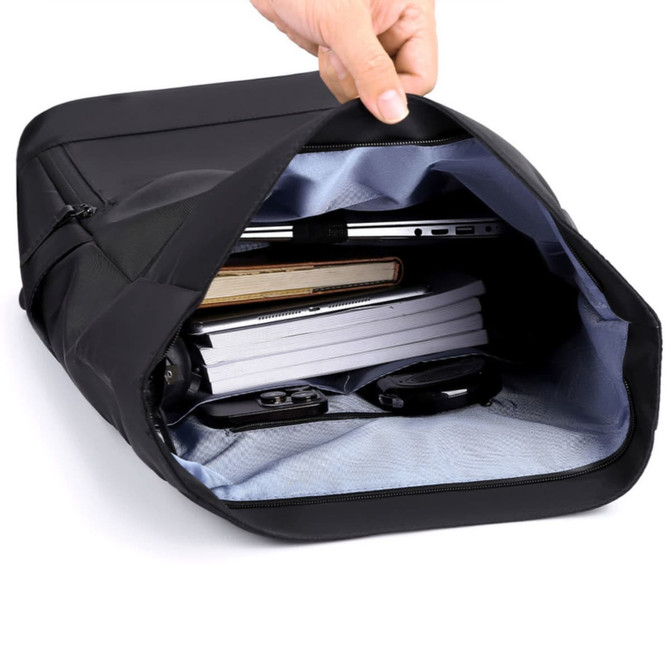 A black roll top laptop backpack, partially opened, revealing books, a laptop, and other accessories inside.