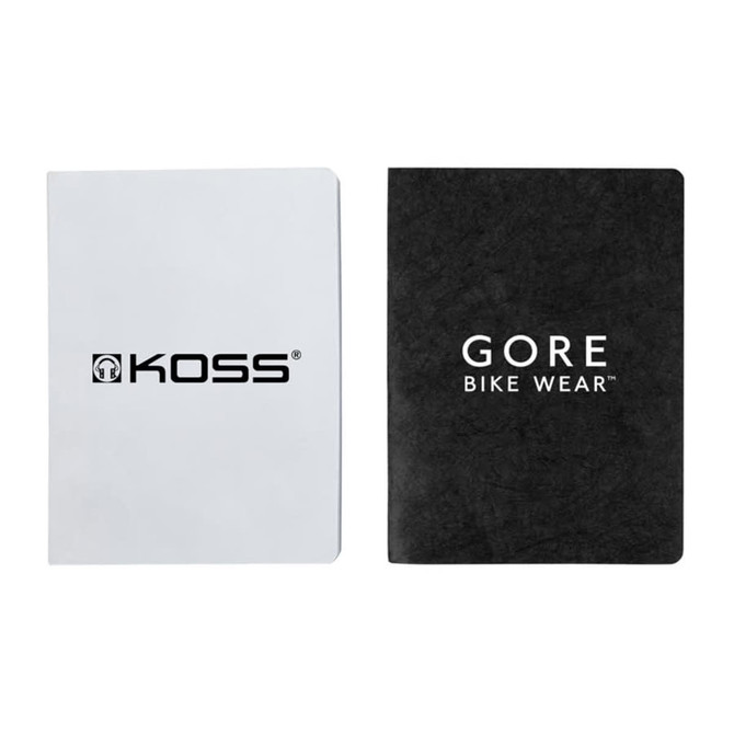 Two notebooks, one with a white cover and a logo, the other with a black textured cover displaying a logo.