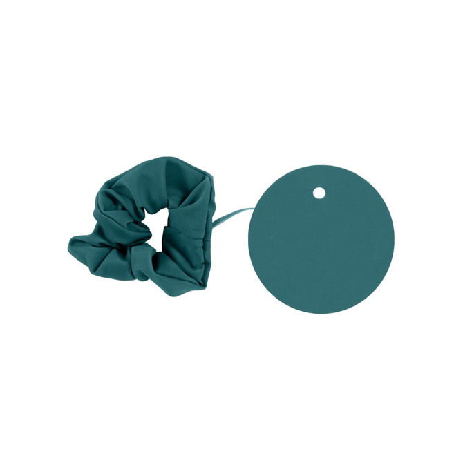 A drink bottle cover in a teal colour alongside a matching circular tag. The cover has a scrunchie design.