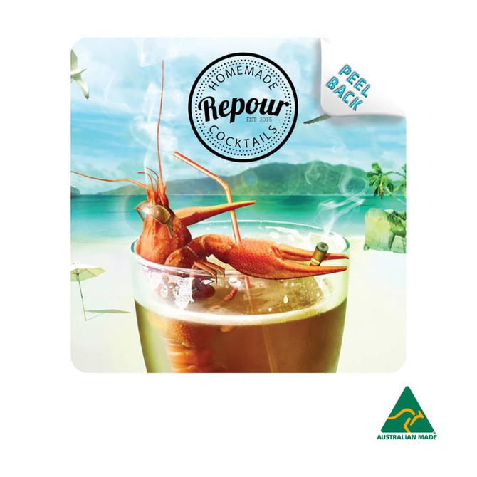 A colourful cocktail with a shrimp garnish rests on a beach-themed coaster featuring a logo and branding.