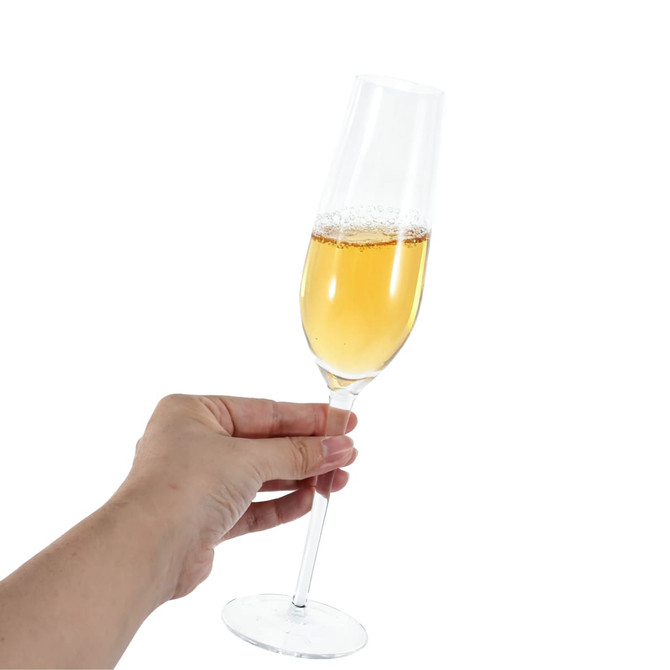 A hand holding a clear classic champagne flute filled with bubbly golden liquid. The glass has a slender stem and base.