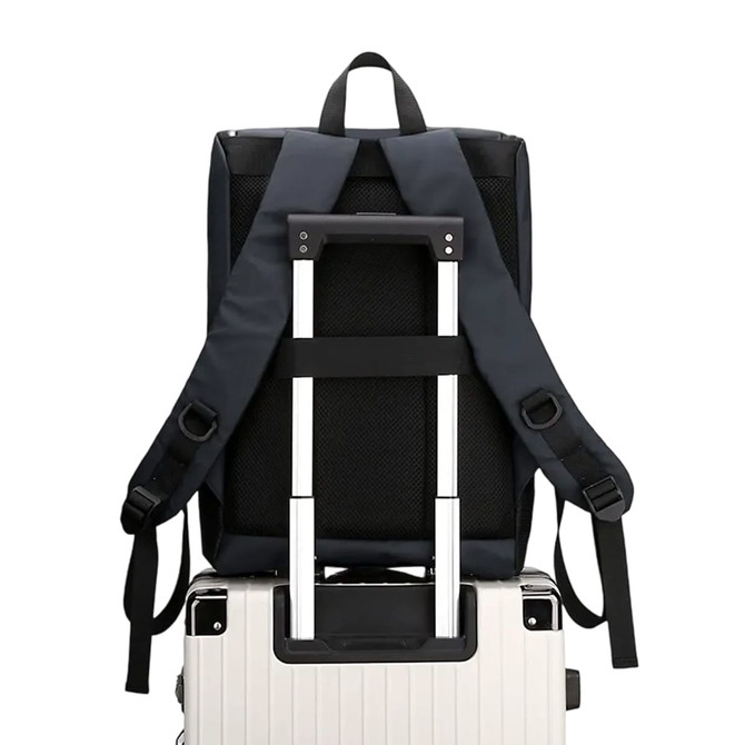A navy blue business laptop backpack with adjustable straps resting on a silver suitcase.