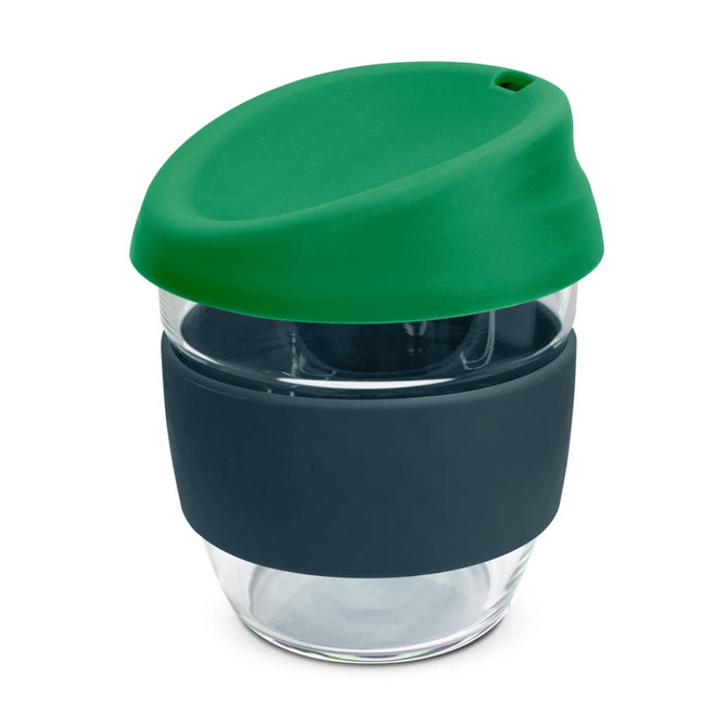 A drink bottle made of clear borosilicate glass with a green silicone lid and a dark blue silicone grip.