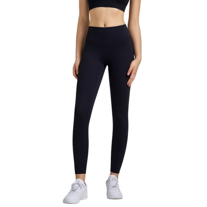 High-waisted black LYCRA yoga leggings displayed on a model, complemented by a black crop top and white sneakers.