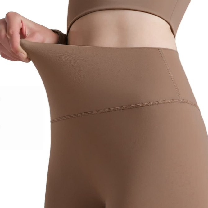 High-waisted elastic LYCRA leggings in a warm brown hue, showcasing flexibility and a smooth fit. Features branding.
