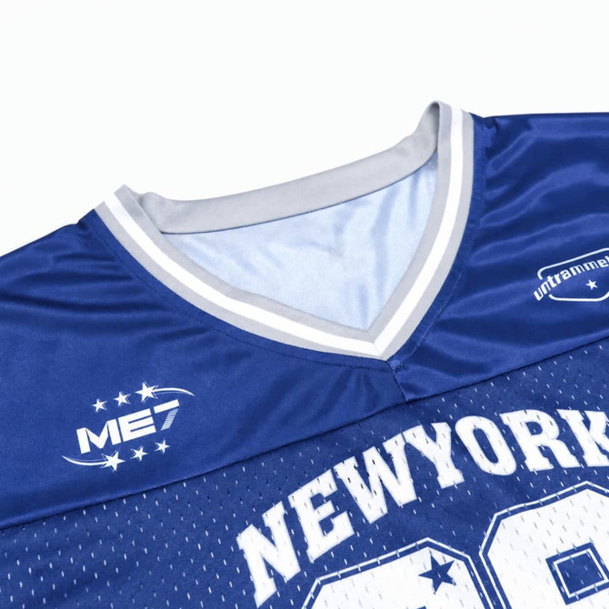 A blue jersey featuring a V-neck design, mesh fabric, and a logo on the shoulder. It includes a splicing detail.