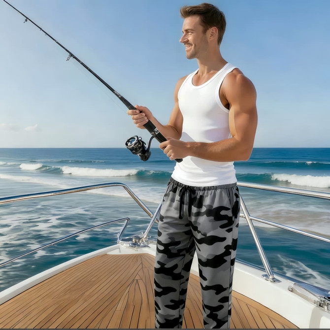 Men's breathable quick-drying fishing pants in camouflage, paired with a white tank top, worn by a man fishing on a boat.