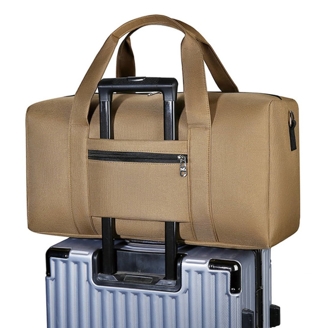 A durable duffle bag in tan sits atop a wheeled suitcase, featuring dual handles and a zippered pocket.
