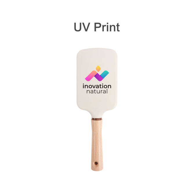 A paddle brush with a white head and a wooden handle, featuring a logo on the surface.