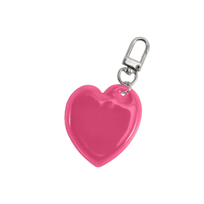 A heart-shaped reflective keychain in vibrant pink with a metal clip attachment.