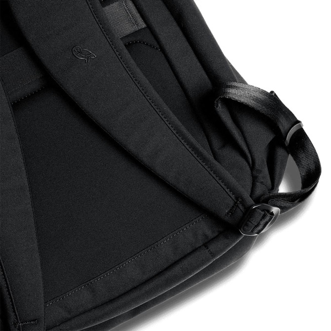 A black backpack featuring padded straps and a sleek design, with a discreet logo on the fabric.