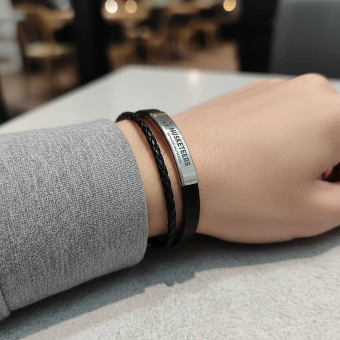 A double-layer leather bracelet featuring black and silver elements, displayed on a wrist against a neutral background.
