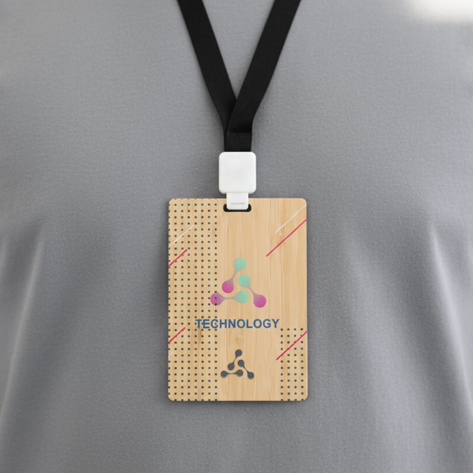 A bamboo name tag attached to a black lanyard, featuring a logo and design elements in various colours.