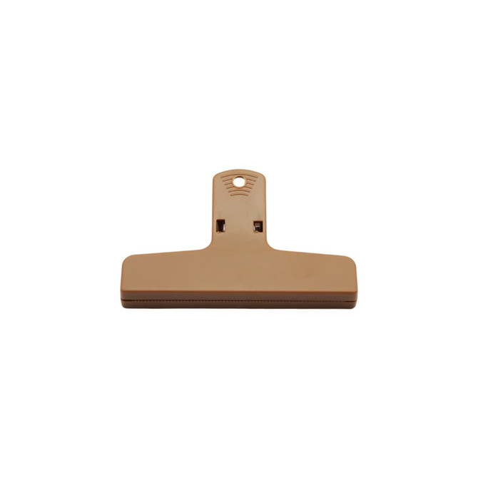 A tan plastic magnetic clip with a large flat surface and a hanging hole for easy storage.