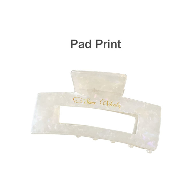 A translucent hair claw clip in a pearl finish, featuring a rectangular opening and a logo.