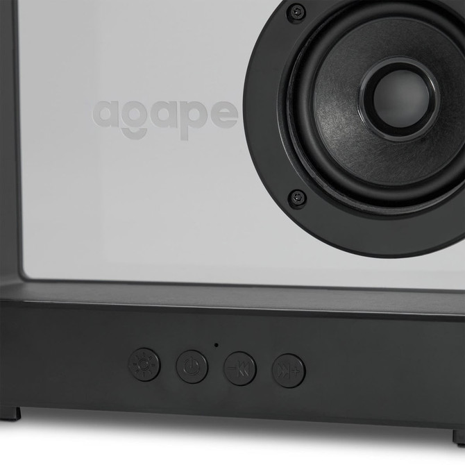 A speaker with a white front and dark grey base, featuring a circular speaker grille and control buttons.