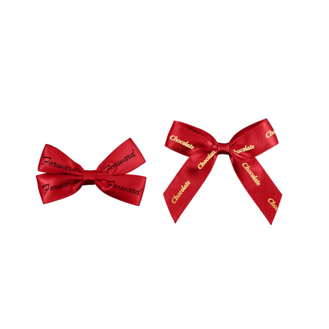 Two red adhesive bows, one with "Forward" and the other with "Chocolate" printed in gold, featuring a logo.