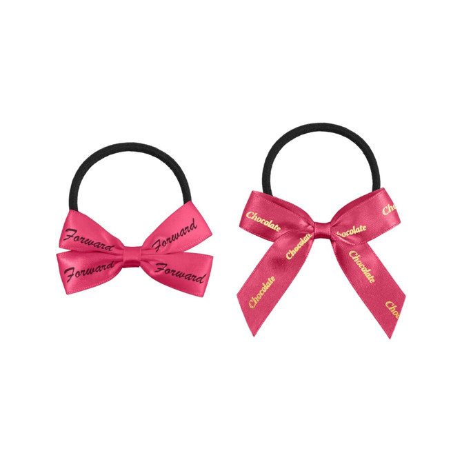 Two elastic hair bows in pink, one with 'Forward' and the other with 'Chocolate' printed in gold. Each is attached to a black elastic band.
