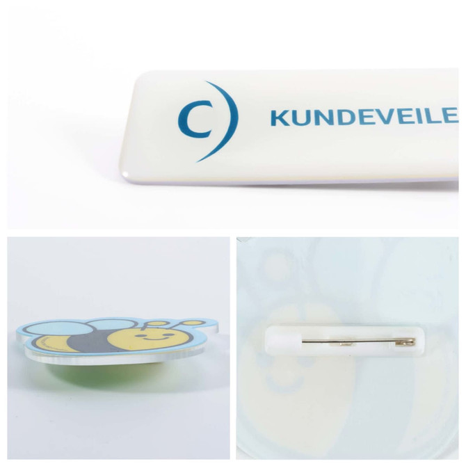 A custom acrylic name badge featuring a bee design with a pin backing, predominantly white and yellow.