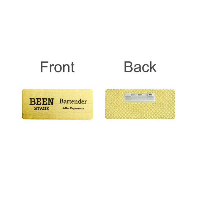A gold metal name badge featuring a front and back design, with a logo on one side and a pin clip on the reverse.