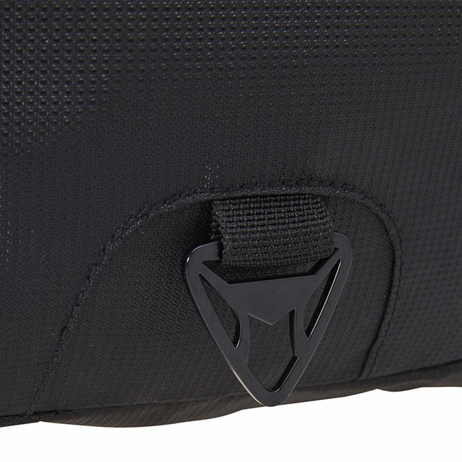 A close-up of a black fabric section of a laptop backpack featuring a logo and a buckle attachment.