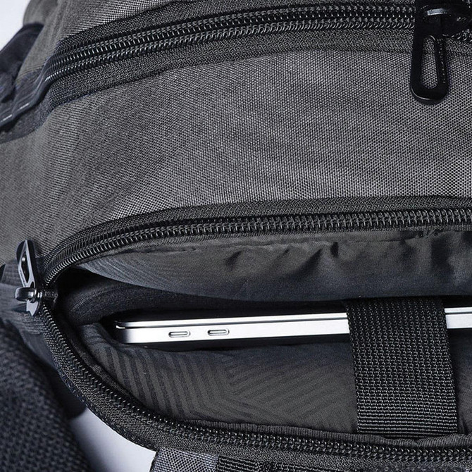 A black backpack with a laptop compartment, showcasing a silver laptop nestled inside.