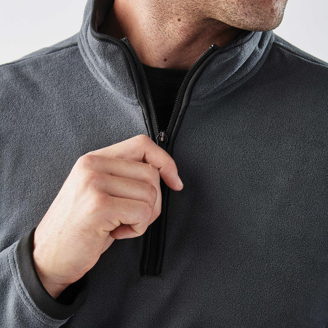 A close-up of a grey men's fleece jumper featuring a 1/4 zip and a discreet logo.