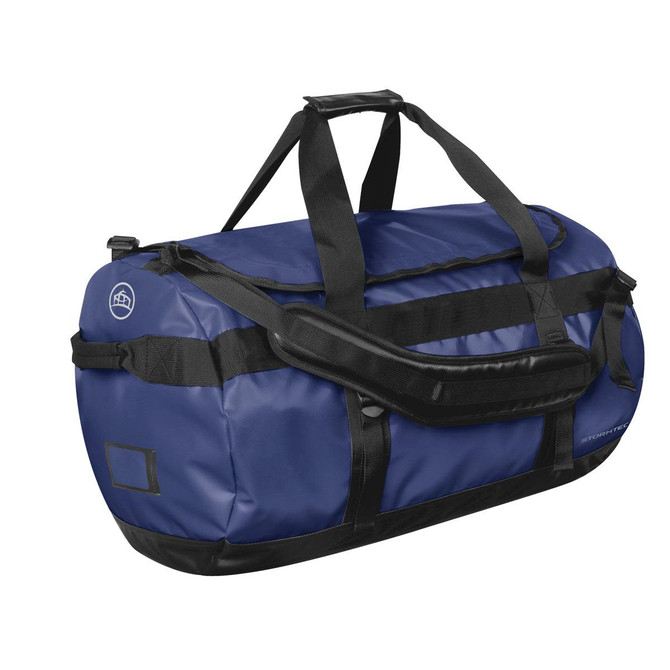 A medium duffle bag in navy blue with black accents and a sturdy handle. It features a logo on one side.