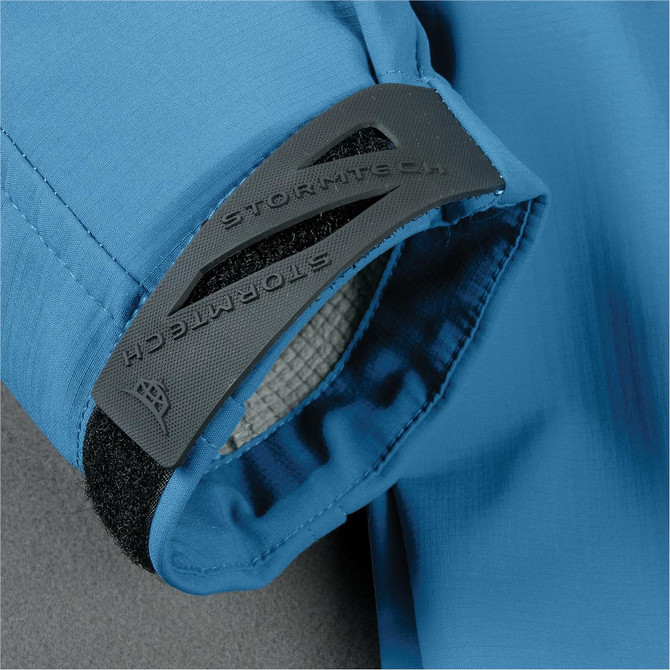 A blue jacket with a black logo patch on the cuff and a textured interior lining.