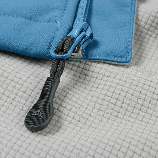 A blue jacket zip featuring a textured grey background, with a contrasting zipper pull. The jacket has a logo present.